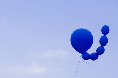 Low angle view of balloons against blue sky