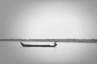 Boats in sea against clear sky