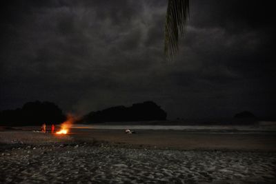 Scenic view of beach against cloudy sky