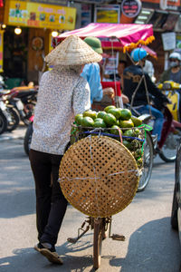 Rear view of woman with umbrella at market stall in city