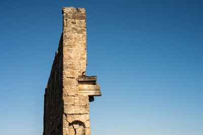 Low angle view of old building against clear blue sky