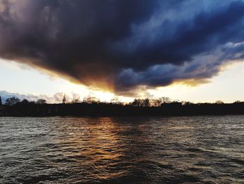 Scenic view of sea against dramatic sky during sunset