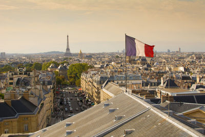 Paris, france, view on skyline and cityscape from the pantheon, french flag waving in foreground