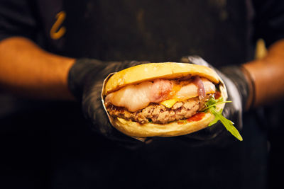 Midsection of man holding burger