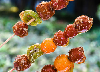 Clode up tanghulu traditional chinese snack of candied hard caramel coated fruit skewers
