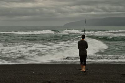 Rear view of person standing on beach