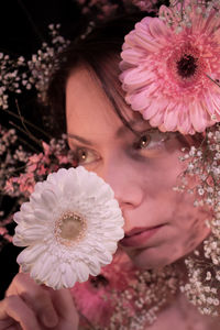 Close-up of woman with pink flower