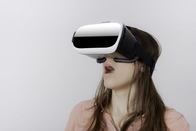 Close-up of woman with virtual reality simulator against wall