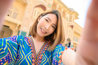 Portrait of smiling young woman against fort