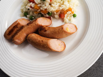 Close-up of rice with sausages served in plate on table