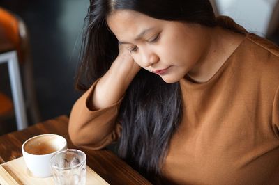 Close-up of woman with coffee cup on table