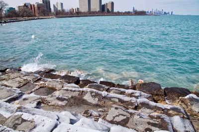 Scenic view of sea by city against sky