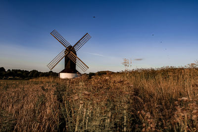 Traditional windmill on field against sky