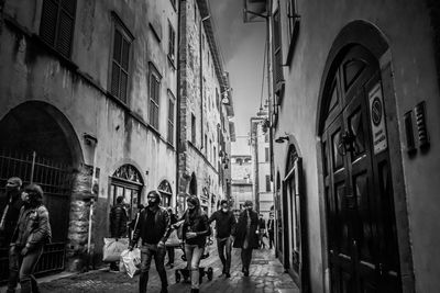 People walking on street amidst buildings in city