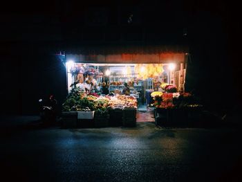 Illuminated store by street at night