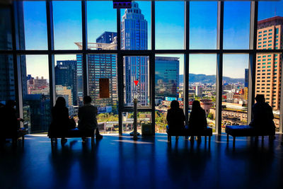 People sitting on sofa in building against sky