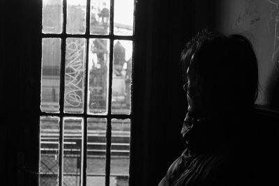 Close-up of woman looking through window at railroad station