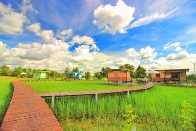 Scenic view of field and buildings against sky