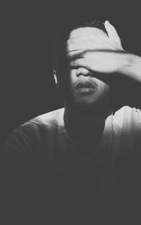 Portrait of young woman against black background