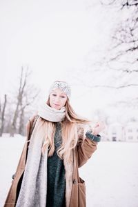 Portrait of young woman standing in snow