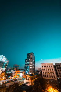 Modern buildings against blue sky at night