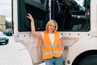 Mature woman standing by truck door