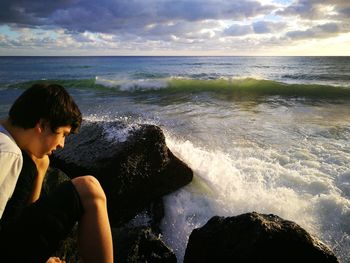 Rear view of woman looking at sea against sky