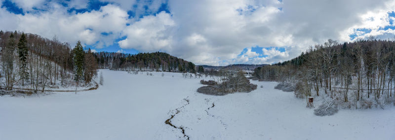 Panoramic view of snow covered land against sky