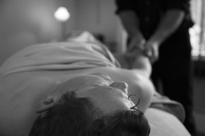Massage therapist massaging man at spa