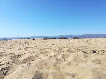 Scenic view of desert against clear blue sky