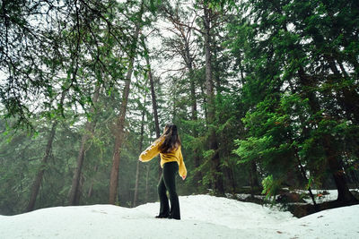 Woman with umbrella on snow covered land