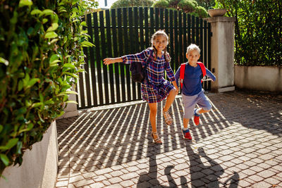 Back to school. siblings with backpacks going to school from home at their first day after vacation