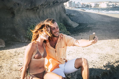 Couple taking selfie with mobile phone at beach