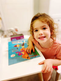 Portrait of cute girl at home playing puzzle 