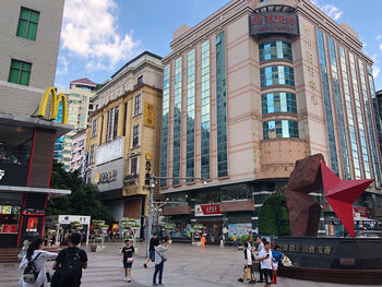 People on street against buildings in city