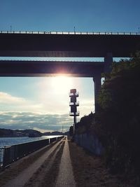 Road by bridge against sky