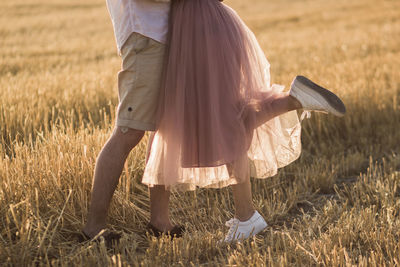 Low section of woman standing on field