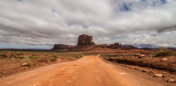 Dirt road on landscape against sky