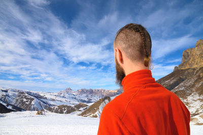 Rear view of man looking at mountain against sky