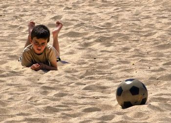 High angle view of boy playing soccer on beach