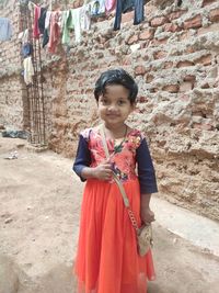 Full length of girl standing against wall