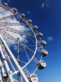 Low angle view of ferris wheel against blue sky