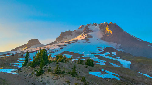 Scenic view of mountains against blue sky