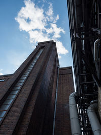Low angle view of brick factory building against sky