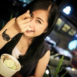 Portrait of a smiling young woman holding ice cream