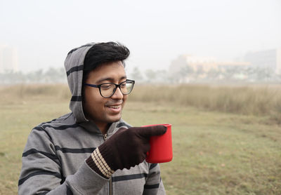 Portrait of young man wearing sunglasses on field