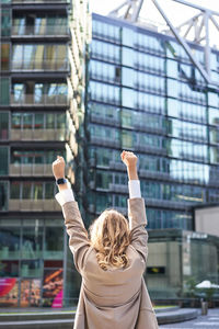 Rear view of woman standing against buildings