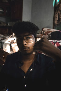 Portrait of serious young man holding string lights