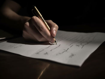 Midsection of woman writing in book