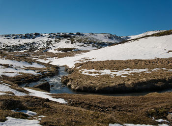 Scenic view of snowcapped mountains against clear blue sky